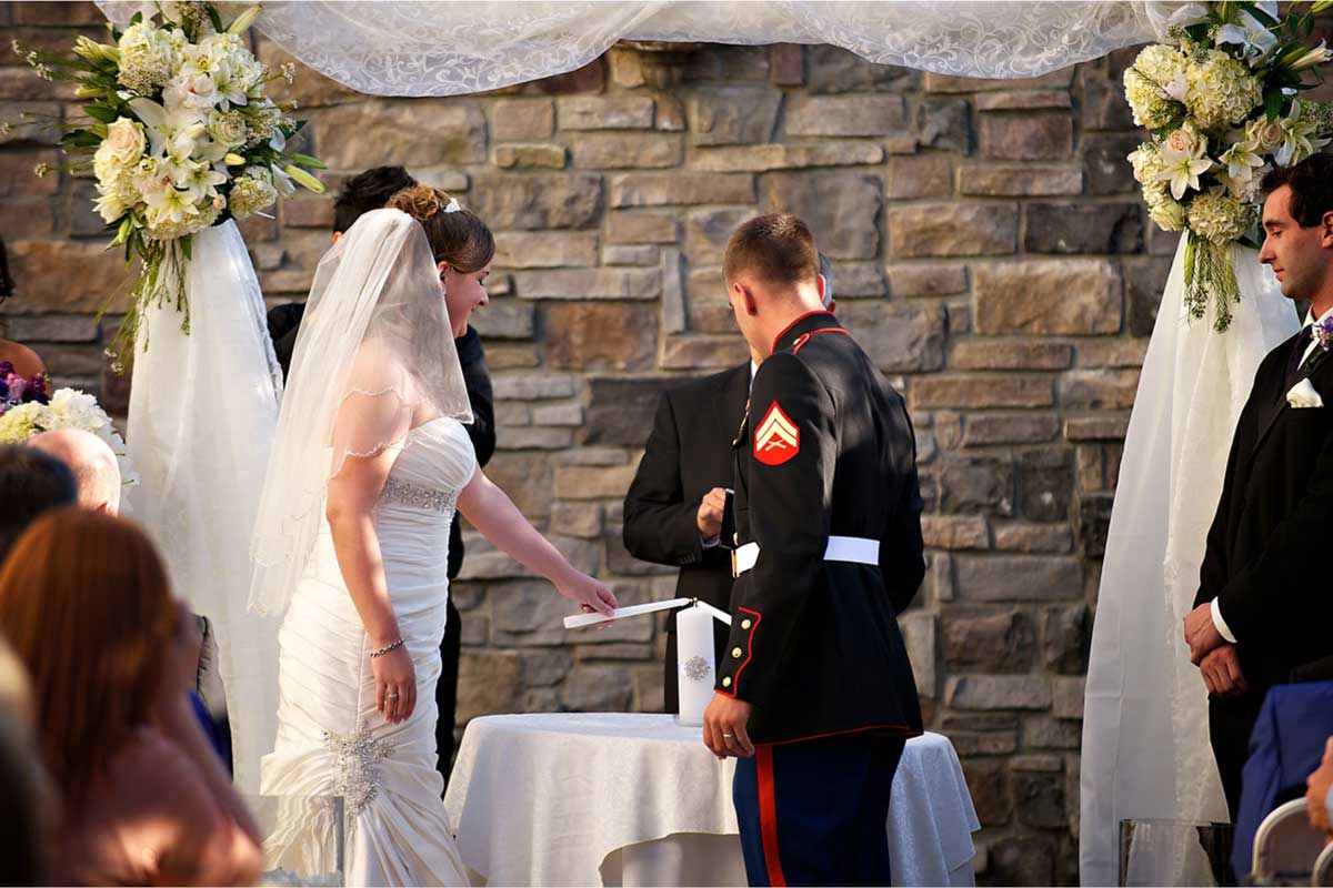 bride-groom-lighting-candle-outdoor-wedding-ceremony-arch